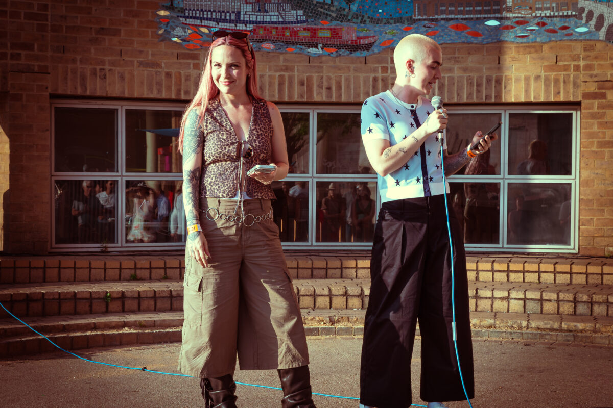 two people on an outdoor platform with a microphone